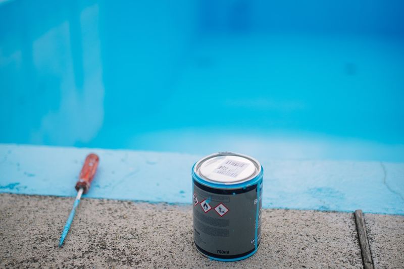 Paint can and brush on concrete